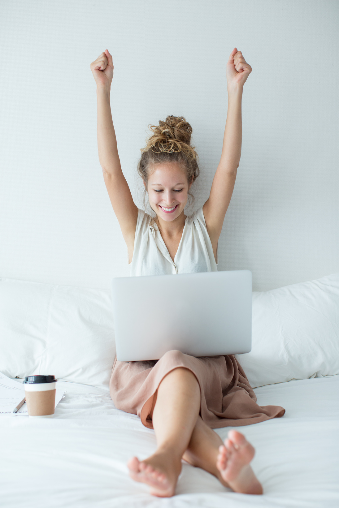 Cheerful Woman with Raised Arms in Front of a Laptop 